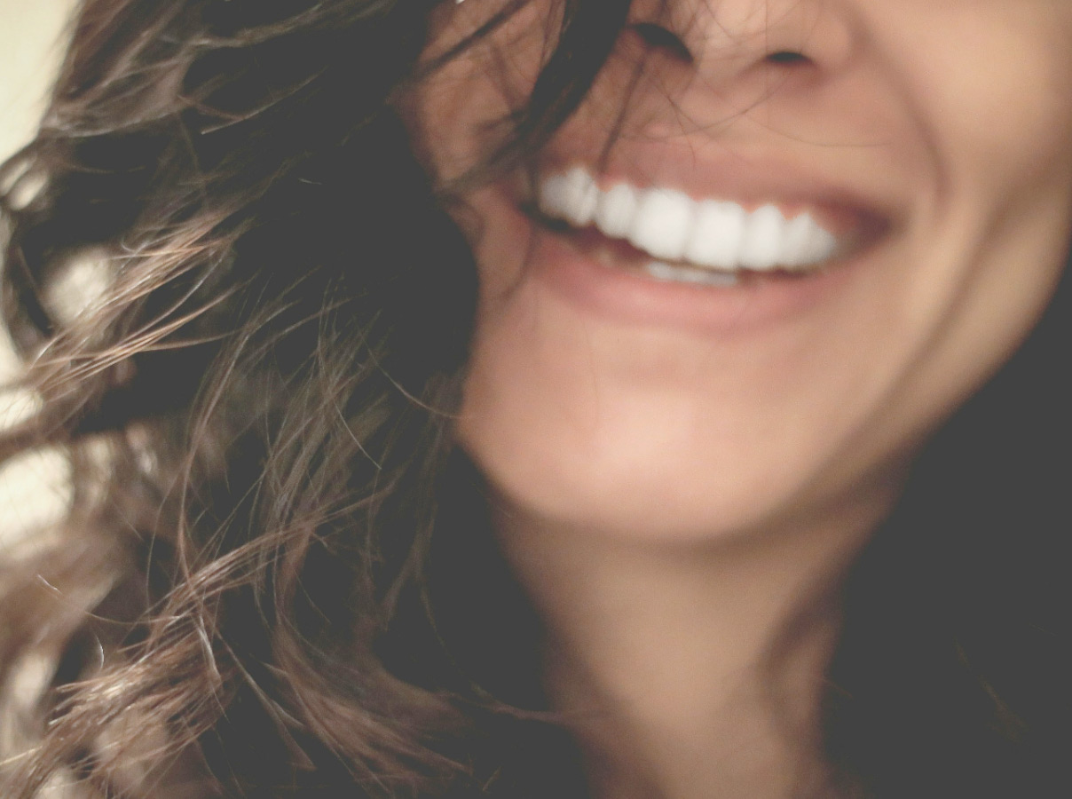 Mujer con una sonrisa que refleja la sanación y el crecimiento personal logrados con la terapia